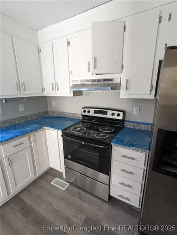 a stove top oven sitting inside of a kitchen