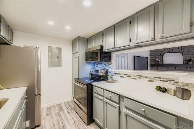 a kitchen with stainless steel appliances a stove refrigerator sink and cabinets