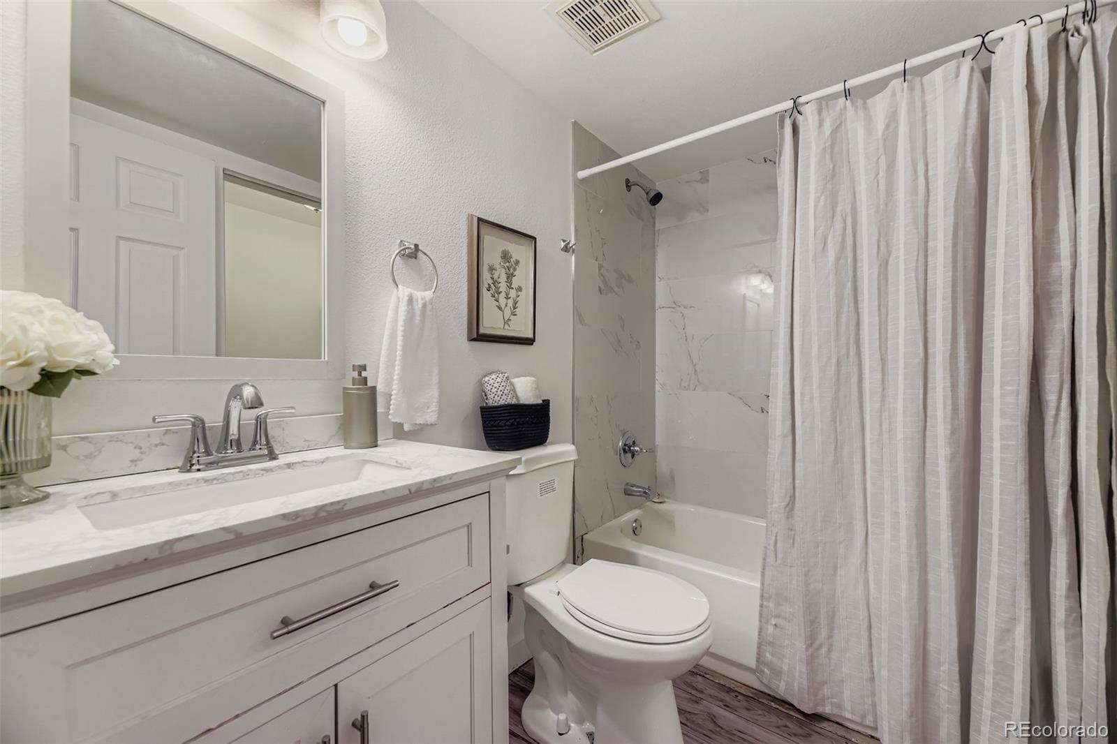 18003 East Ohio Avenue, Unit 102 Aurora, CO 80017 - Photo 10 of 11 a bathroom with a sink toilet and shower