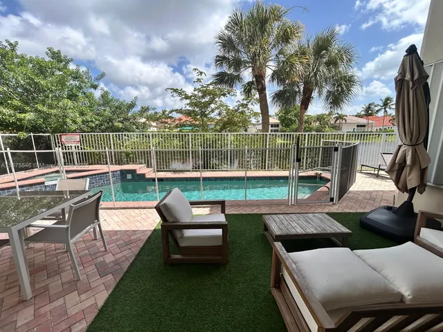 a view of a patio with swimming pool and furniture