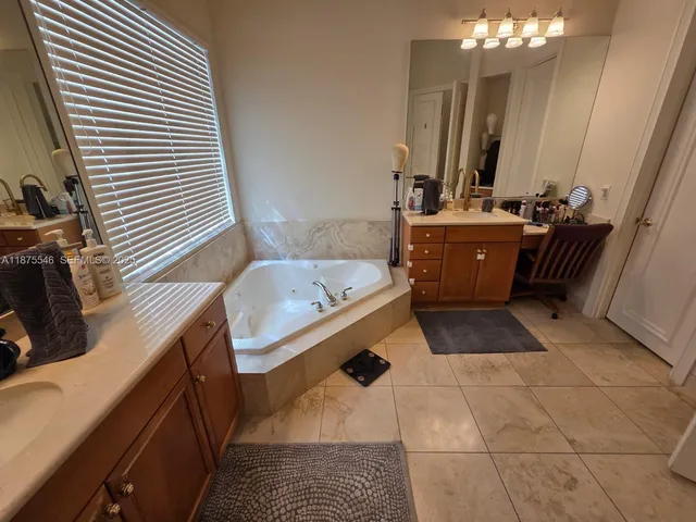 a bathroom with a tub sink and mirror