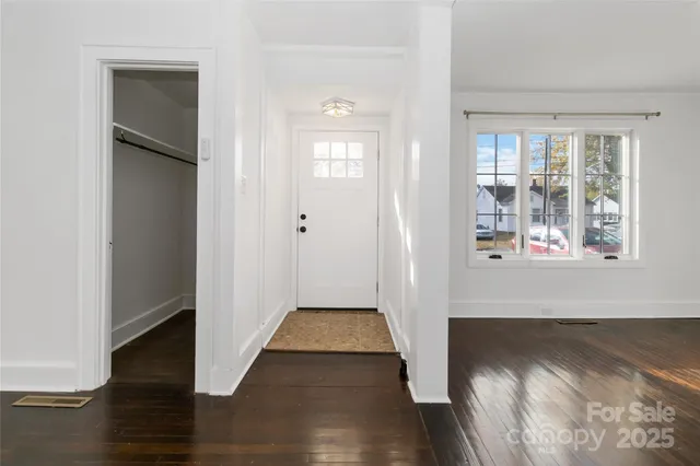 a view of empty room with window and wooden floor