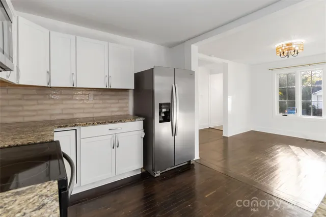an empty room with wooden floor ceiling fan and windows