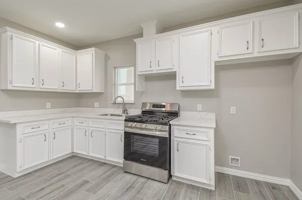 a kitchen with granite countertop white cabinets and white appliances