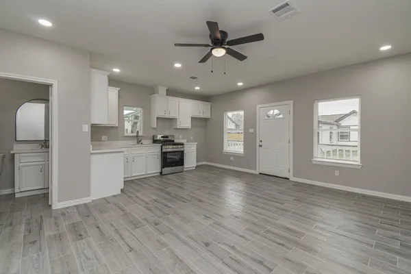 a view of a kitchen with a sink and dishwasher a refrigerator with wooden floor