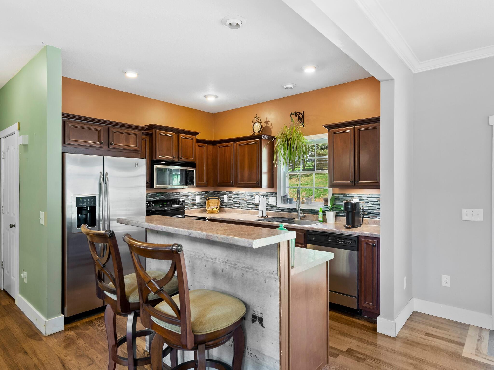 480 Meadowview Drive Saluda, NC 28773 - Photo 11 of 44 a kitchen with a sink a refrigerator and chairs