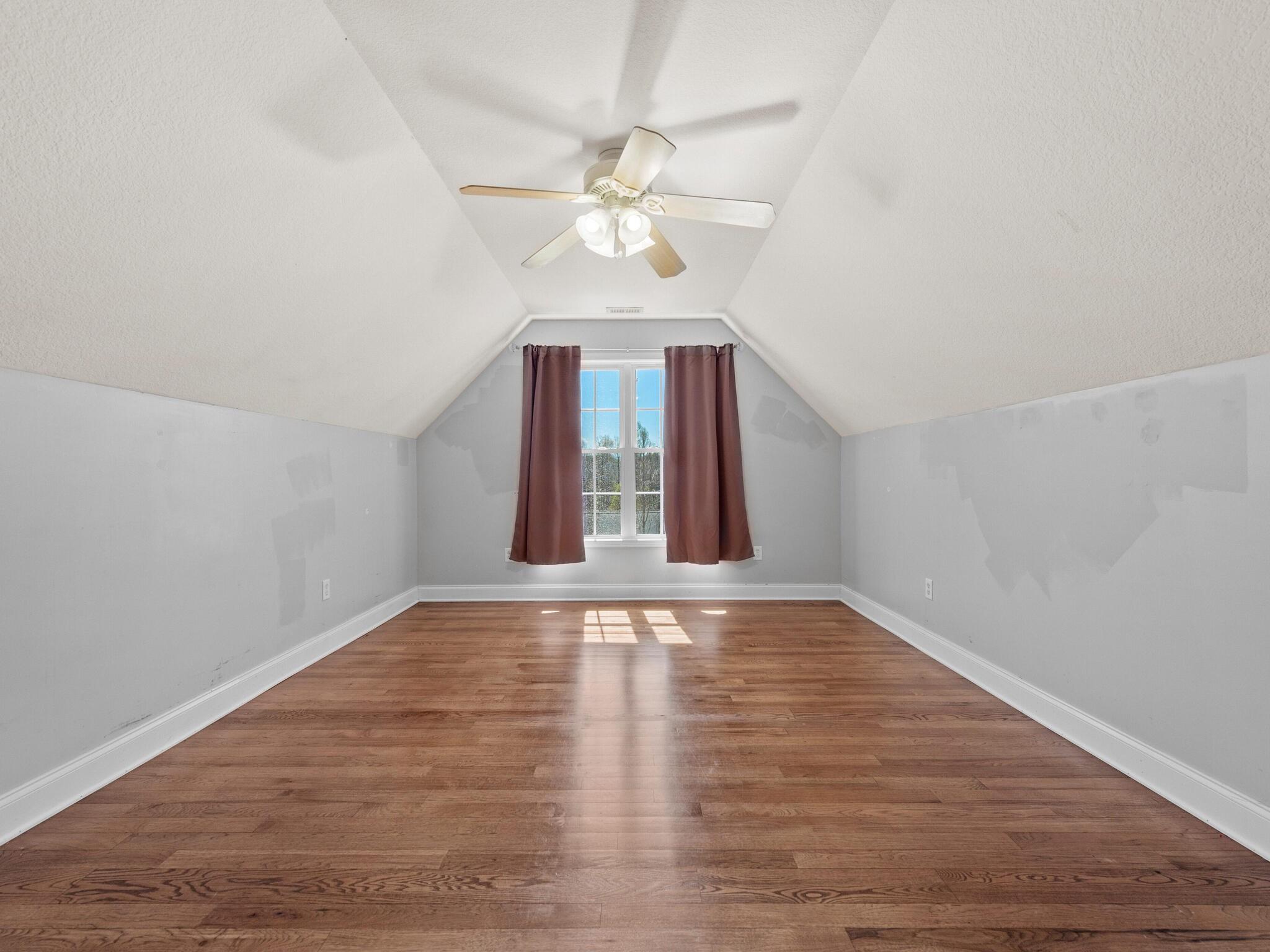 480 Meadowview Drive Saluda, NC 28773 - Photo 24 of 44 a view of an empty room with wooden floor and a ceiling fan