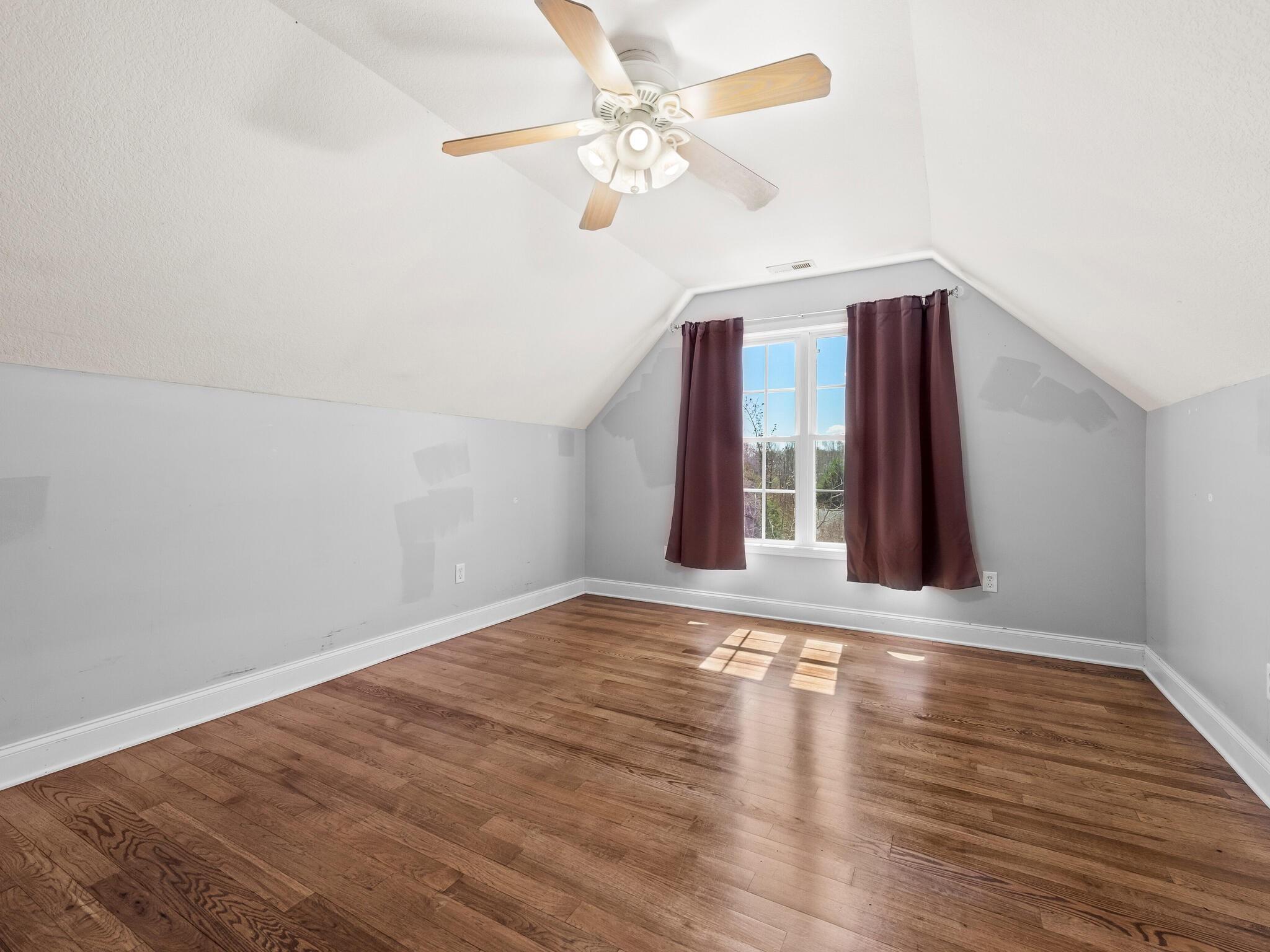 480 Meadowview Drive Saluda, NC 28773 - Photo 25 of 44 a view of an empty room with wooden floor and a ceiling fan