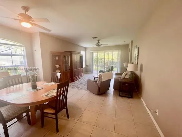 a large living room with furniture a table and a chandelier
