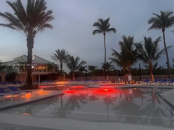 a view of swimming pool with palm trees