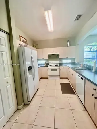a kitchen with white cabinets a sink and stainless steel appliances