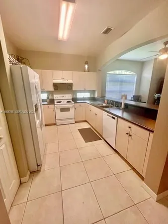a kitchen with a sink a stove a microwave and a refrigerator