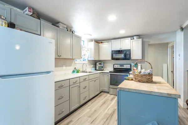 a kitchen with sink refrigerator and microwave