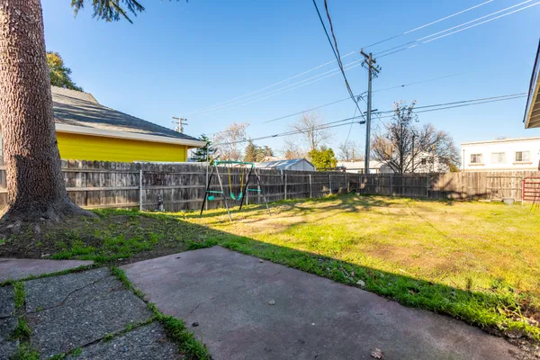 a view of a swimming pool with a patio and a yard