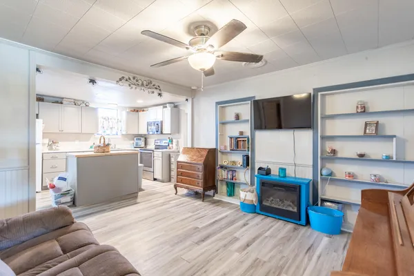 a living room with stainless steel appliances kitchen island furniture and a kitchen view