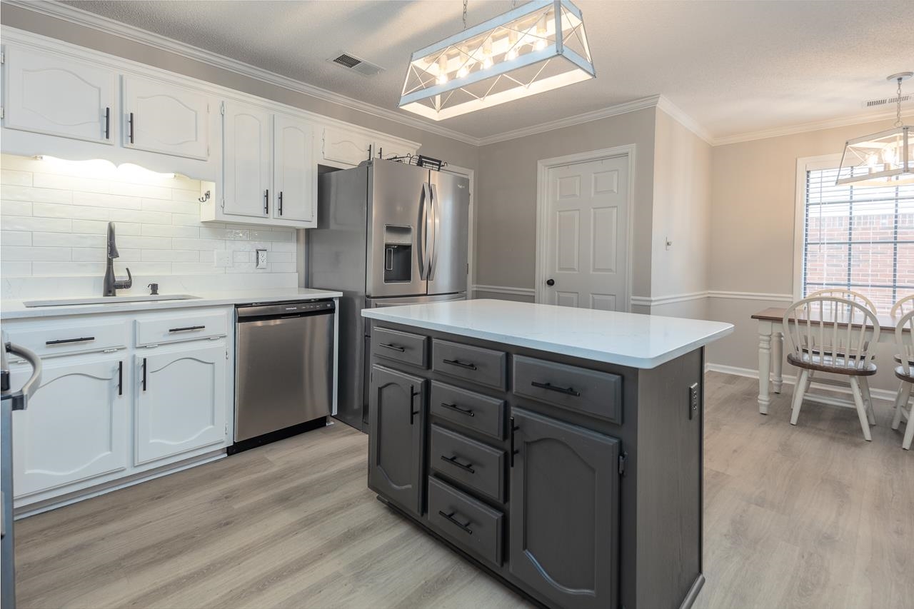 6490 Stone Lake Drive Bartlett, TN 38135 - Photo 11 of 32 a kitchen with stainless steel appliances granite countertop a sink cabinets and wooden floor