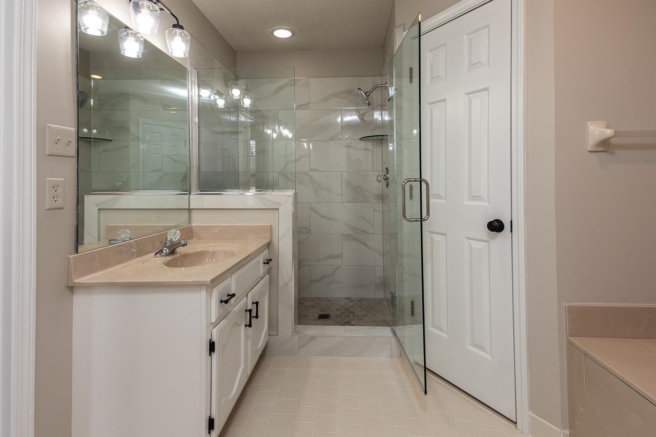 6490 Stone Lake Drive Bartlett, TN 38135 - Photo 18 of 32 a spacious bathroom with a shower a sink and mirror