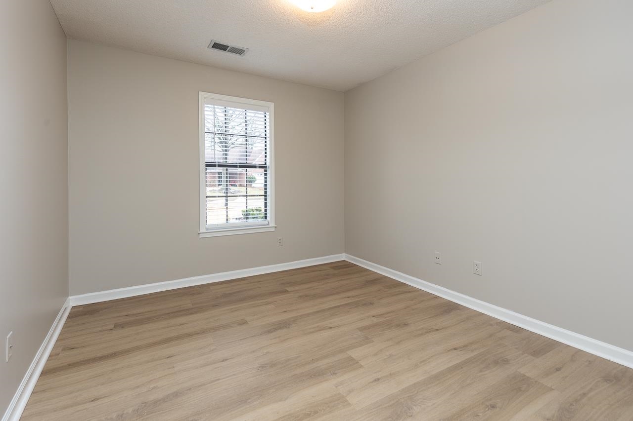 6490 Stone Lake Drive Bartlett, TN 38135 - Photo 22 of 32 an empty room with wooden floor and windows