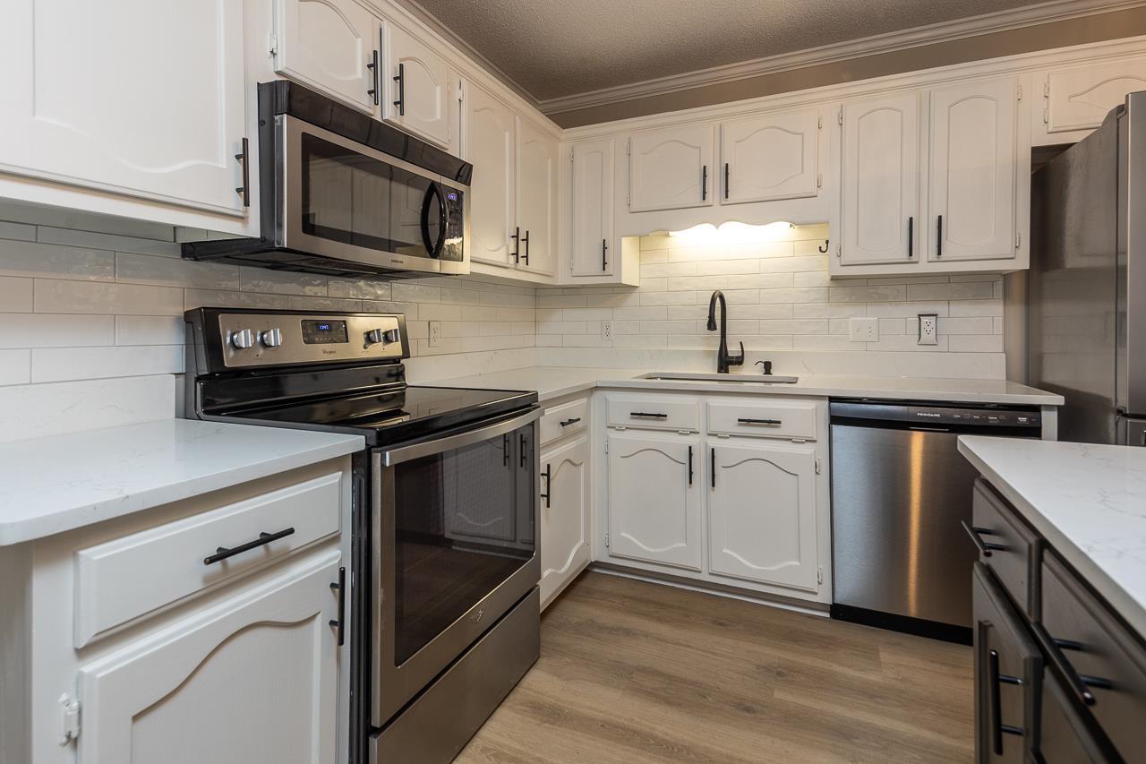 6490 Stone Lake Drive Bartlett, TN 38135 - Photo 10 of 32 a kitchen with cabinets stainless steel appliances a sink and a stove