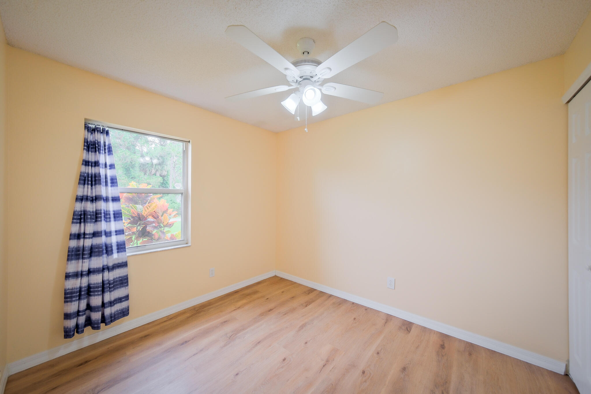 762 Gerlitz Road Southwest Palm Bay, FL 32908 - Photo 20 of 29 an empty room with wooden floor fan and windows