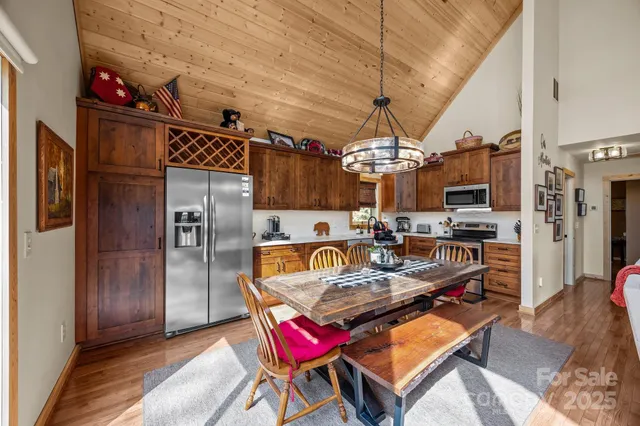 a living room with furniture a chandelier and kitchen view