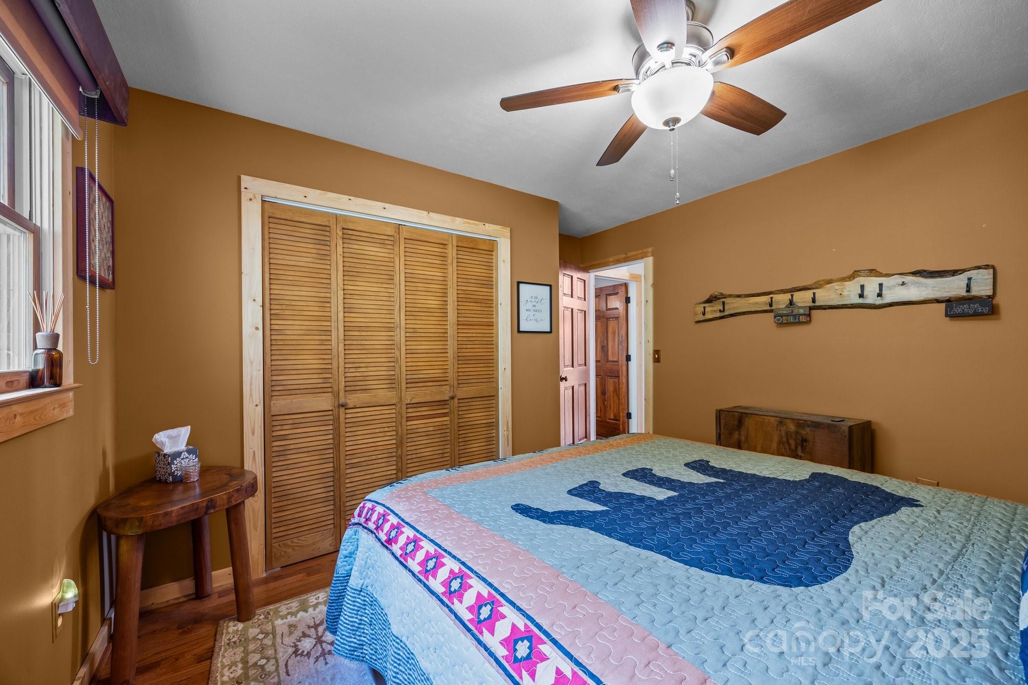 1954 Utah Mountain Road Waynesville, NC 28785 - Photo 26 of 39 a bedroom with a bed and a chandelier