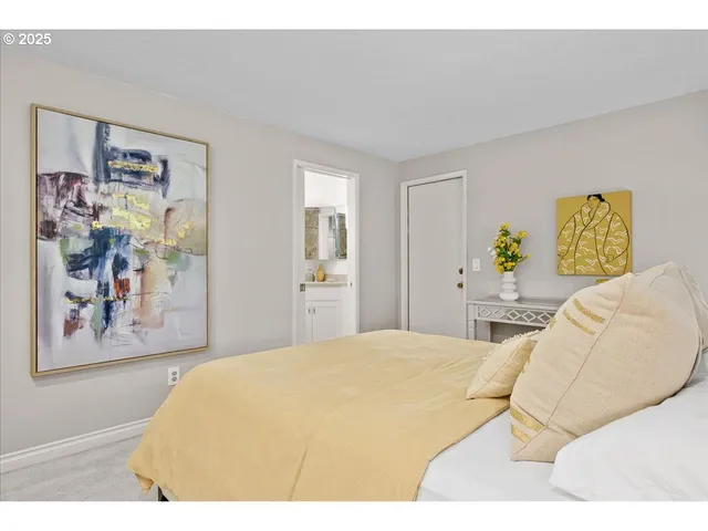 a bedroom with a bed and painting on the wall