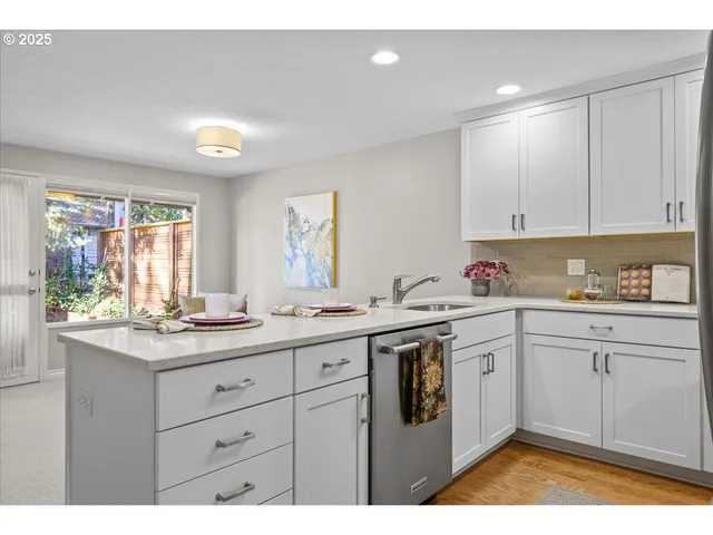 a kitchen with a sink window and cabinets