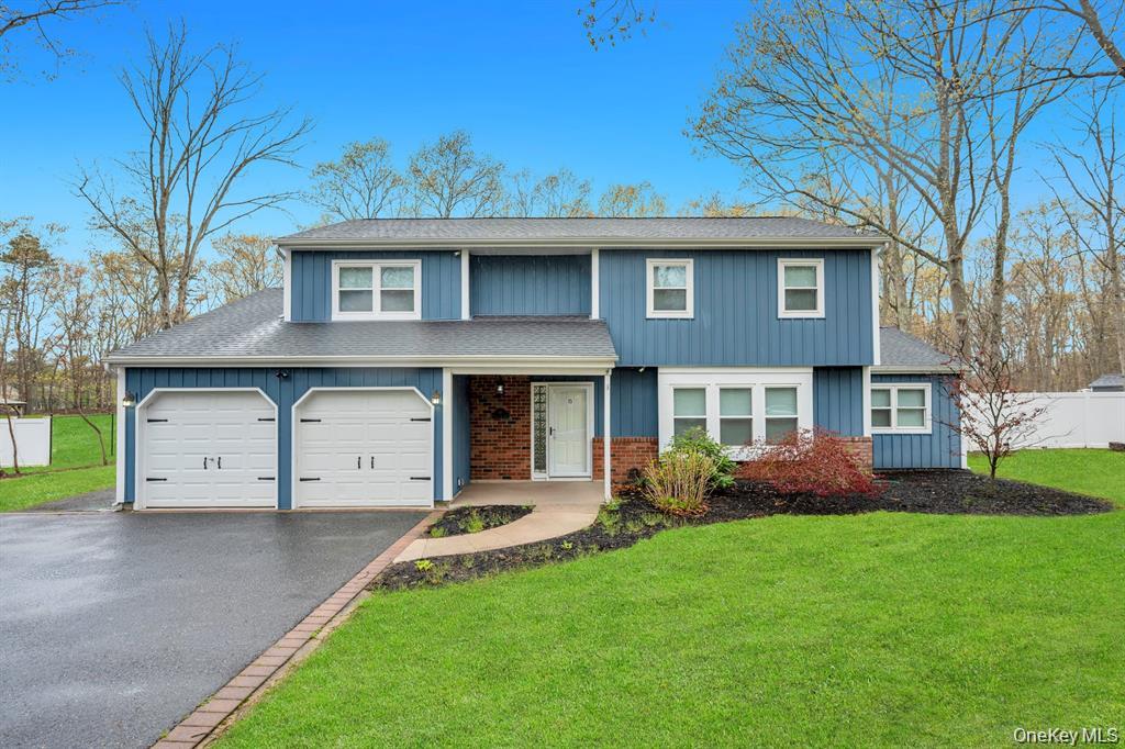 10 Ramblewood Road Ridge, NY 11961 - Photo 3 of 39 a front view of a house with a garden and yard