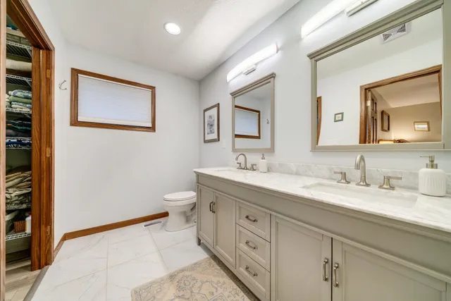 a en suite bathroom with a double vanity sink and a mirror