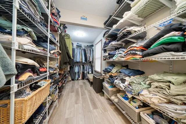 a view of walk in closet with clothes and shoes