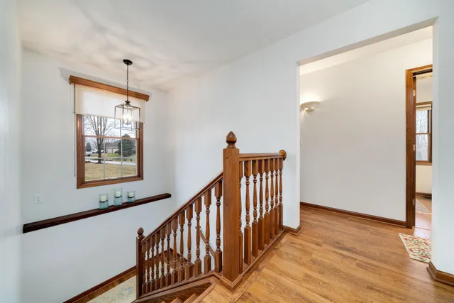a view of a hallway with wooden floor and staircase