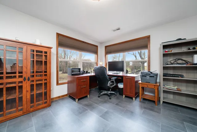 a view of a workspace with furniture and a window