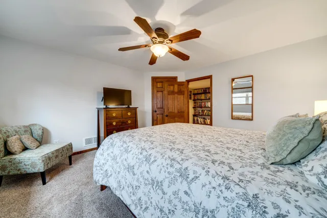 a bedroom with a bed couches and a flat screen tv