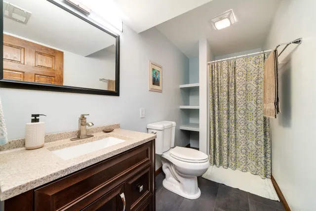 a bathroom with a granite countertop sink toilet and shower