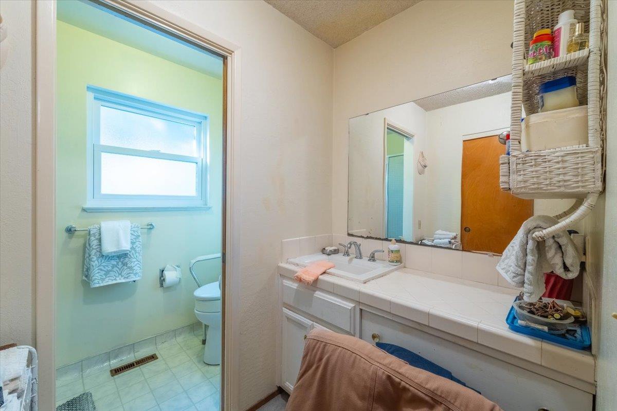 18117 Berta Canyon Road Salinas, CA 93907 - Photo 33 of 56 a bathroom with a sink a toilet and a mirror