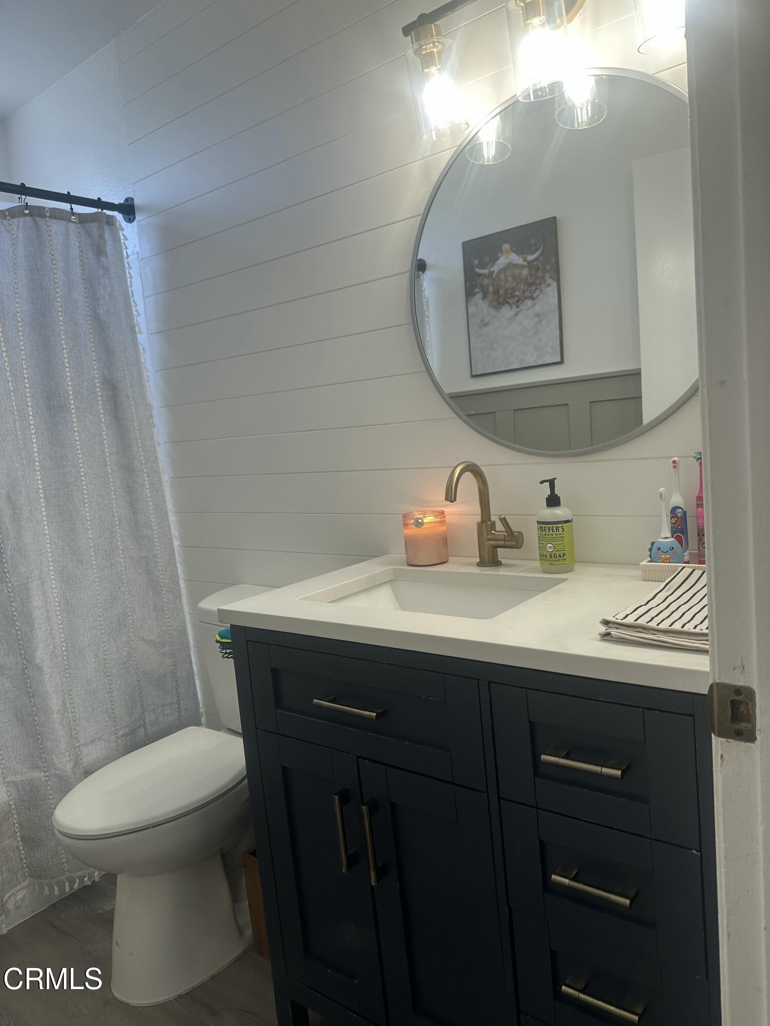 5246 Longfellow Way Oxnard, CA 93033 - Photo 10 of 15 a bathroom with a sink a toilet and shower curtain