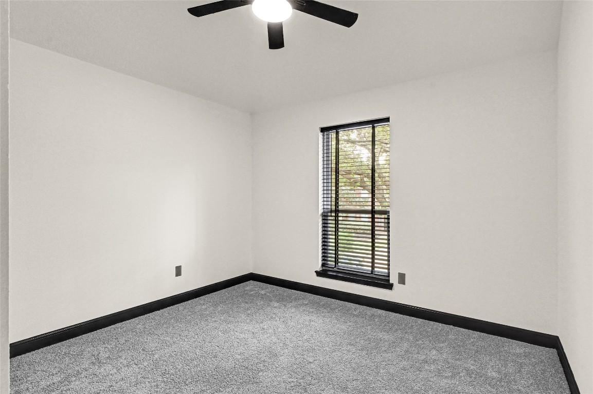11915 Helene Court Pinehurst, TX 77362 - Photo 16 of 33 an empty room with a chandelier fan and windows
