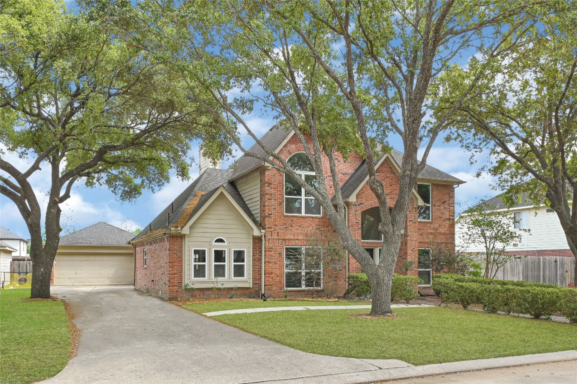11915 Helene Court Pinehurst, TX 77362 - Photo 2 of 33 a view of a house next to a yard with large trees