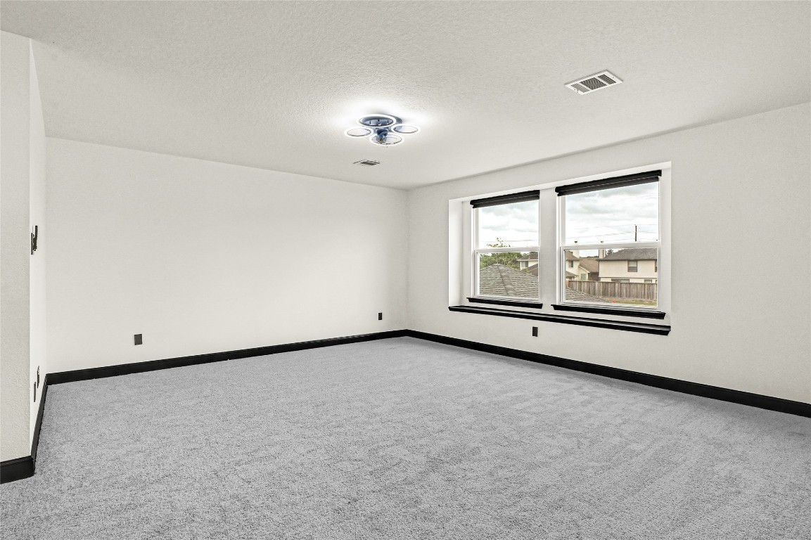 11915 Helene Court Pinehurst, TX 77362 - Photo 22 of 33 an empty room with chandelier fan and windows
