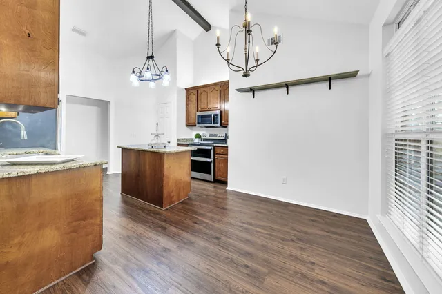 a view of a kitchen with a sink wooden floor and stainless steel appliances