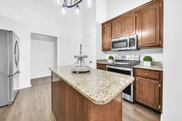 a kitchen with granite countertop a stove and a microwave