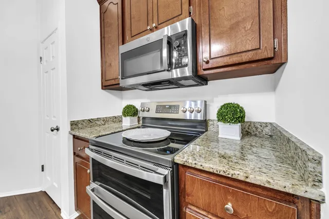 a kitchen with stainless steel appliances granite countertop a sink stove and cabinets