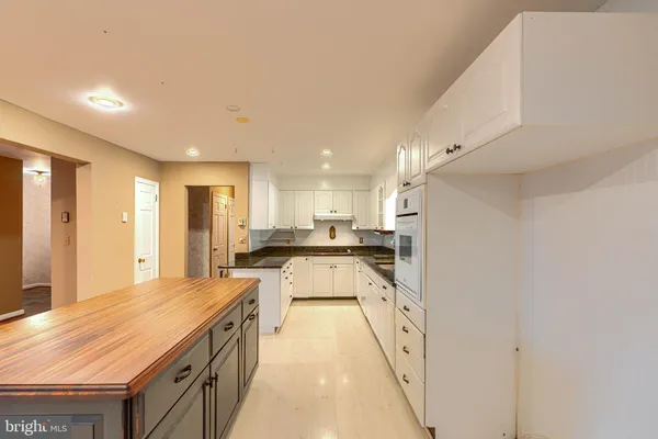 a large kitchen with stainless steel appliances granite countertop a large counter top and a stove