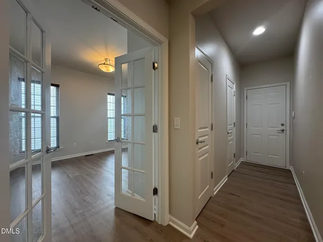 a view of a hallway with wooden floor and windows
