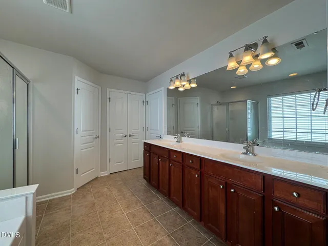 a spacious bathroom with a double vanity sink and a mirror