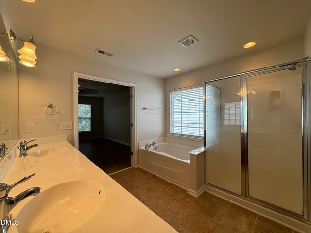 a bathroom with a tub sink and mirror