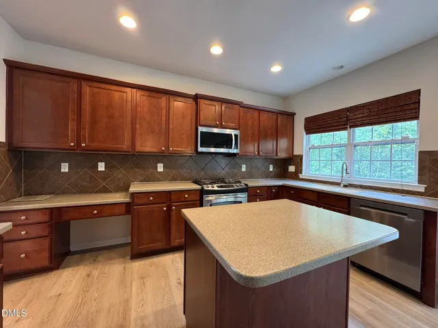 a kitchen with stainless steel appliances granite countertop a sink stove microwave and cabinets