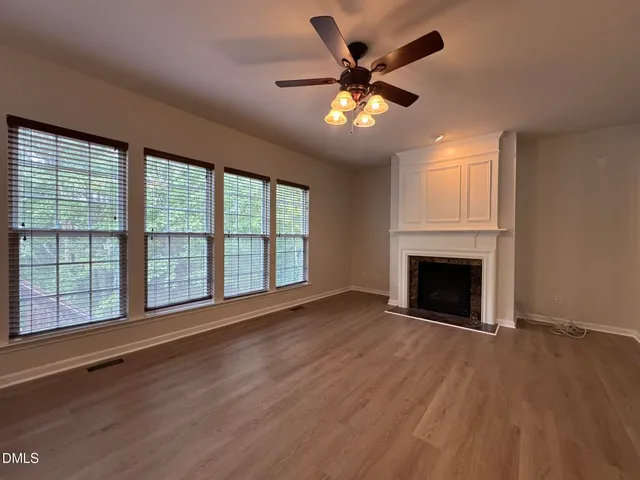 a view of an empty room with a fireplace and a window