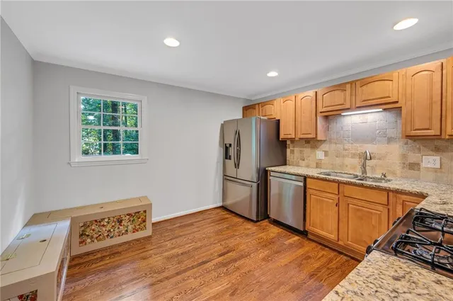 a kitchen with stainless steel appliances granite countertop a refrigerator sink and stove
